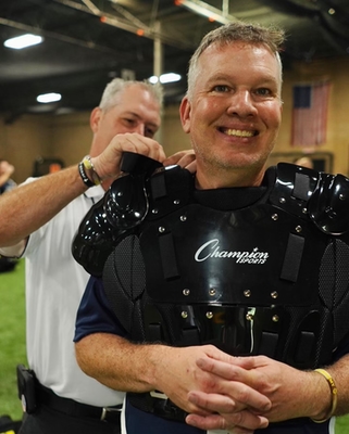 WWUA Instructor Helps Student with Umpire Chest Protector