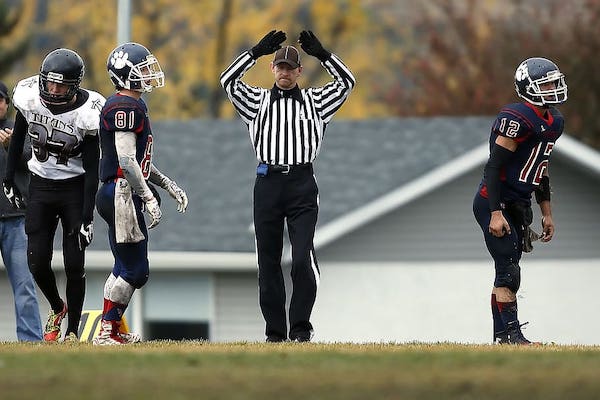 Football Referee Holds Up Hands and Gloves